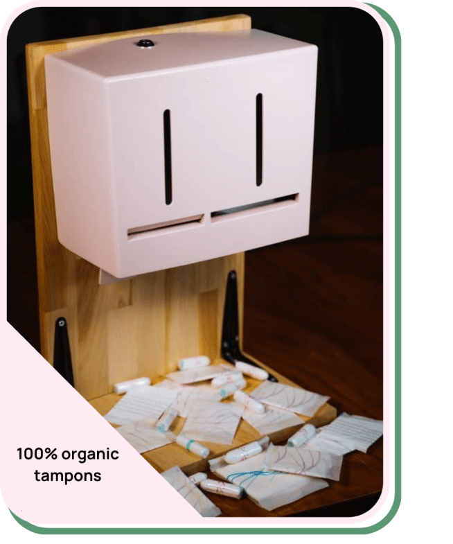 Hier wordt een roze tampon dispenser laten zien van Herbox die 100% biologische menstruatieproducten uitgeeft.