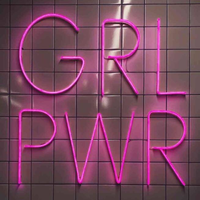 Rosa neon-skylt med texten ‘’GRL PWR’’ på kaklad bakgrund.