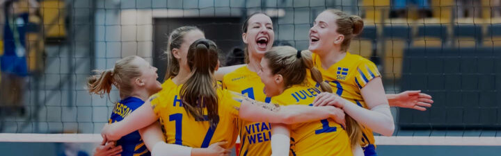 Svenska damlandslaget i volleyboll i gula tröjor kramar varandra framför ett volleybollnät.