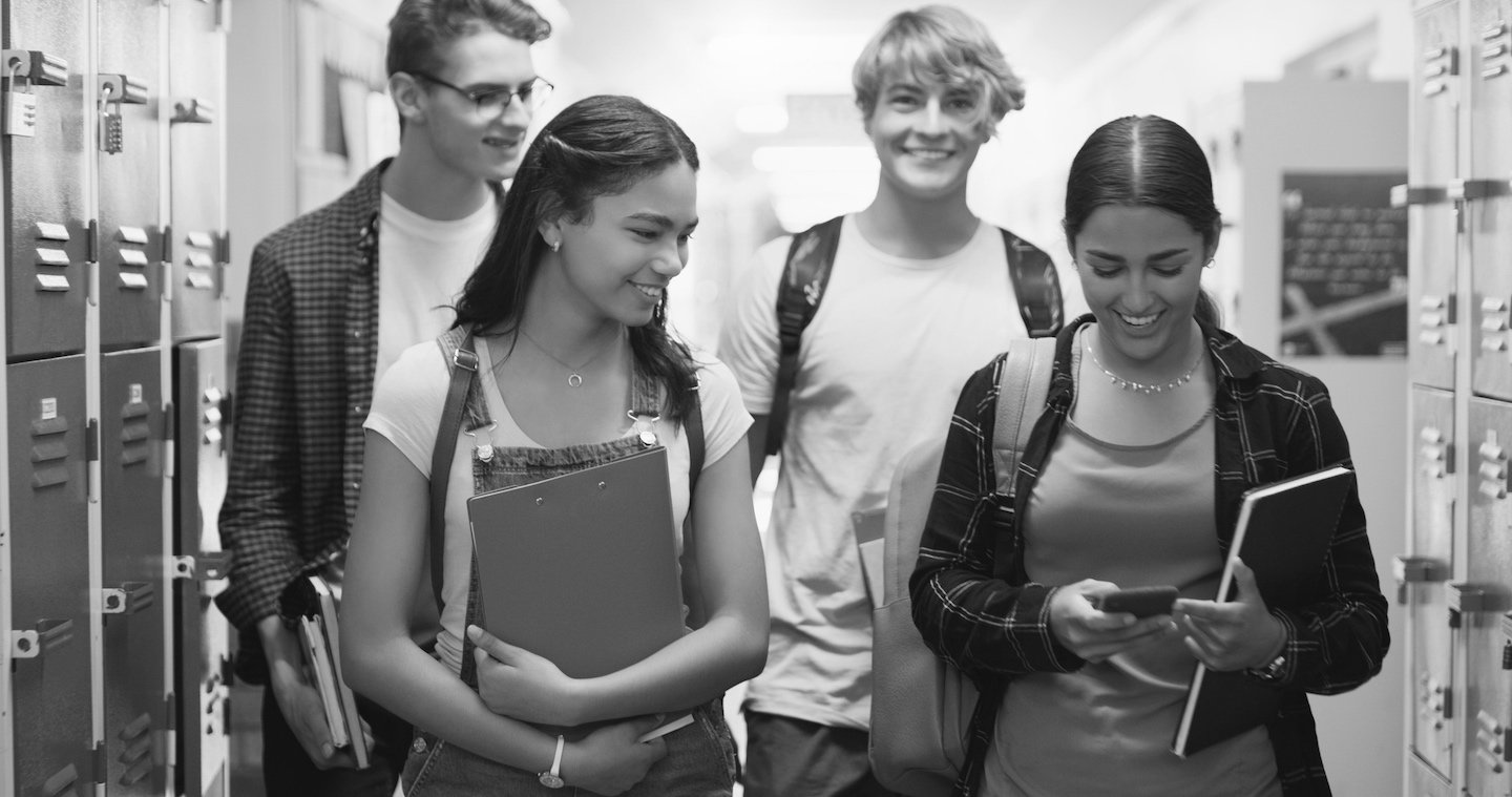 Gymnasieelever i korridor med skolböcker - Herbox mensskydd i skolan