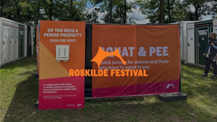Festival sign offering free period products and squat toilets, with trees and portable toilets in the background. By Roskilde x Herbox