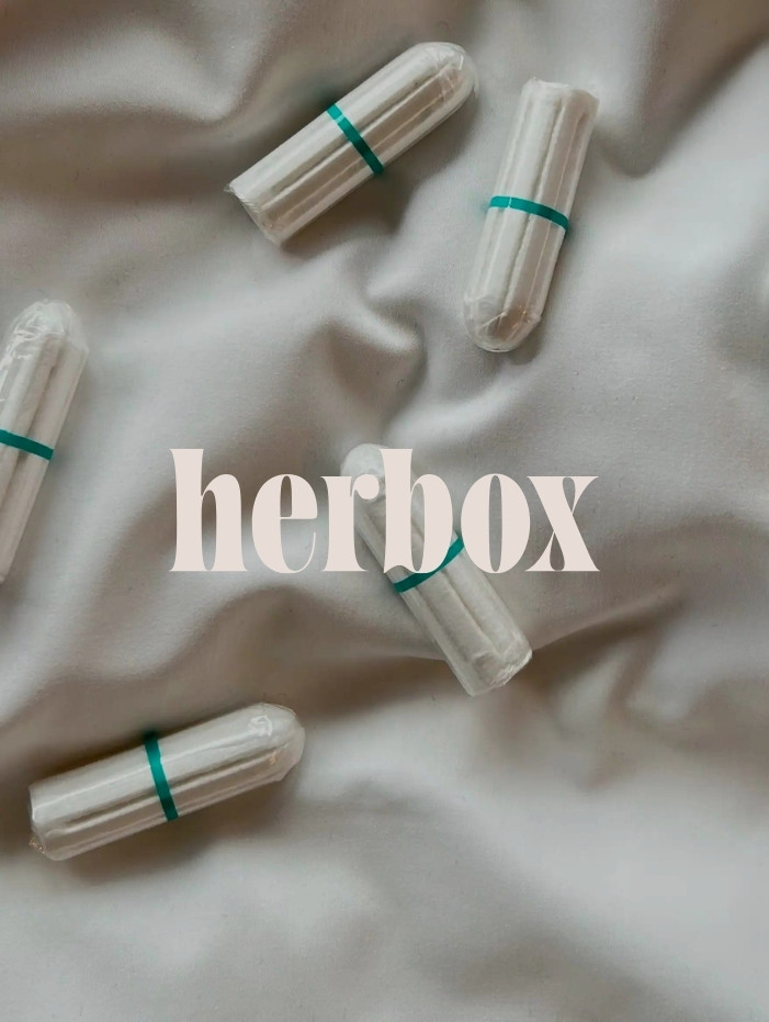 Flera tamponger på ett skrynkligt tyg med texten "herbox" i bakgrunden.