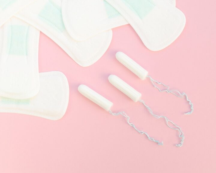 Hygienbindor och tamponger på en rosa bakgrund.