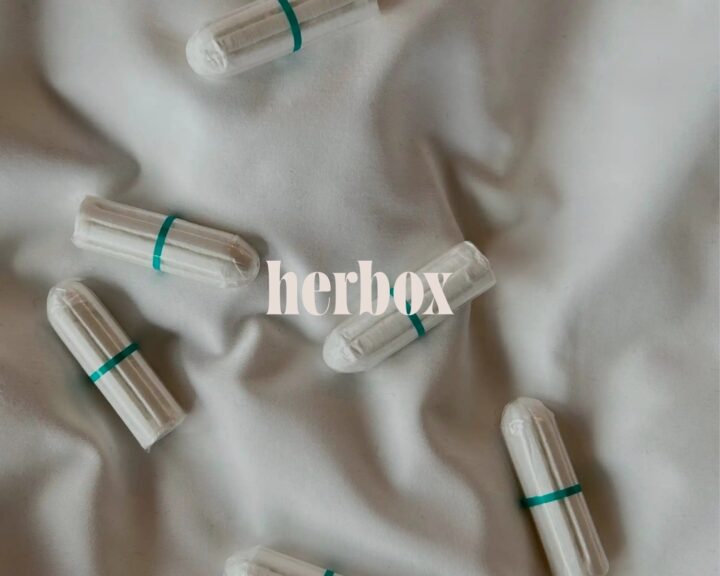 Tamponger på en hotellsäng med ordet "herbox" över dem.